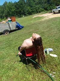 Washing wife's hair outside in the country