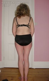 Showing off her slender legs and her shapely ass in black firming panties